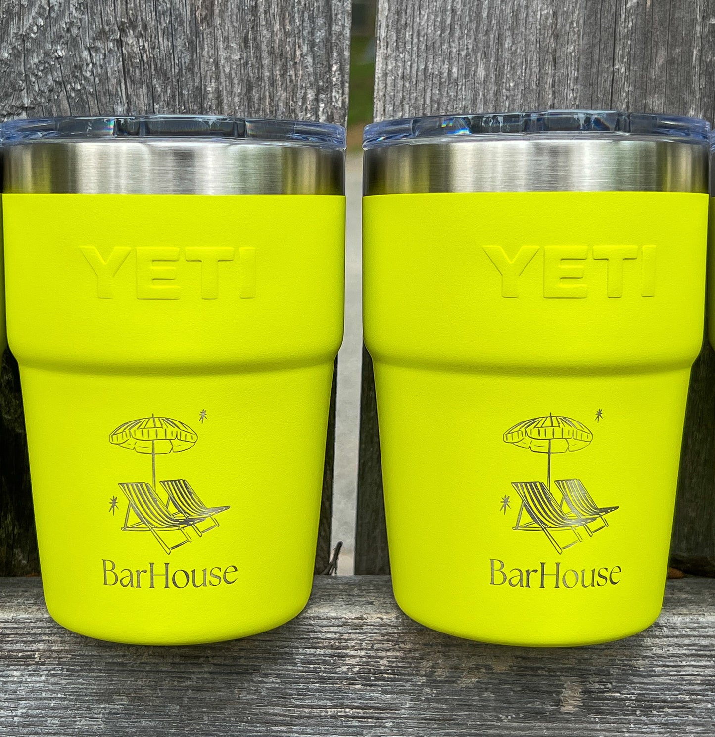 2 Firefly Yellow Yeti 16oz Rambler Stackable Tumbler with a laser engraved logo on a wooden surface outdoors.