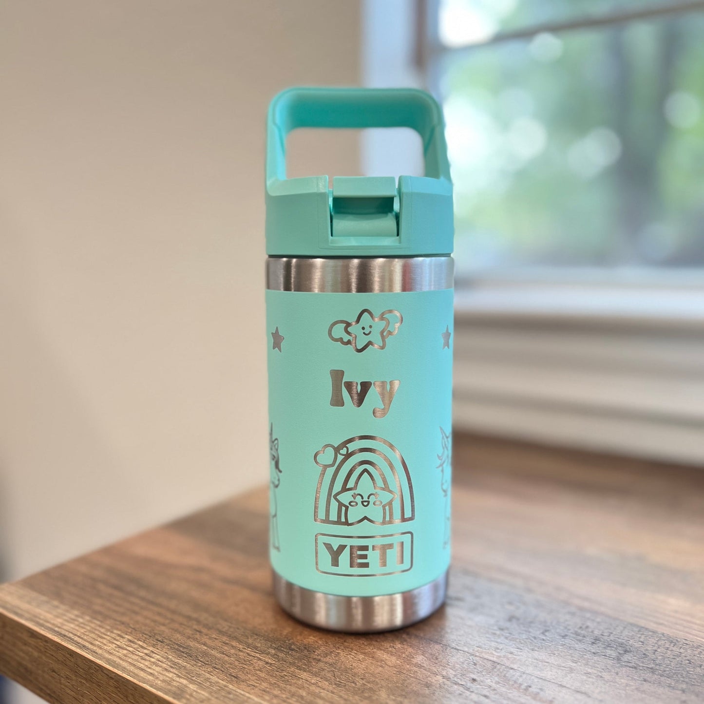 Personalized Kids Yeti 12 oz Water Bottle 12 Design Options - Pine LaserworksSeafoam YETI water bottle with 'Ivy' on a wooden surface