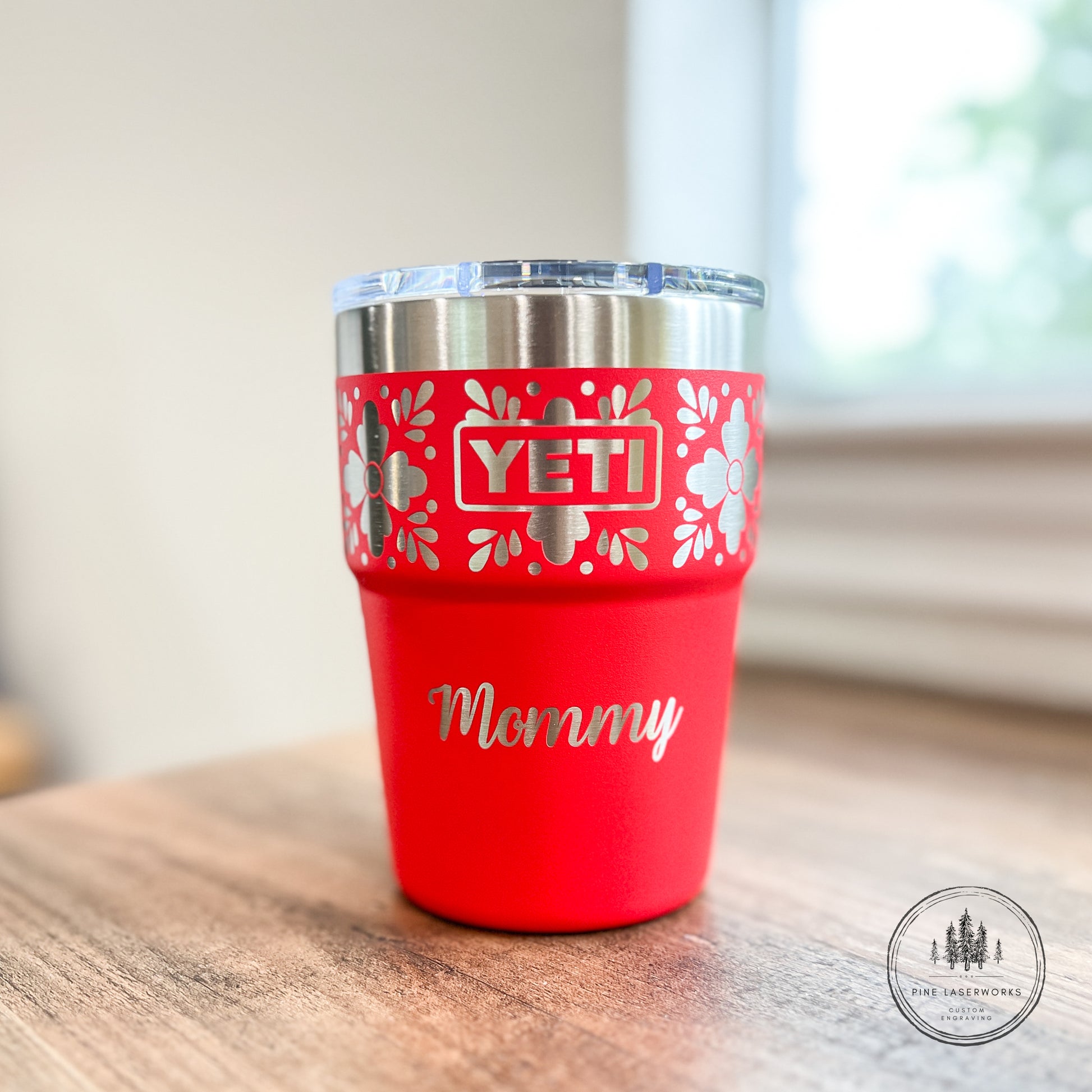 Red YETI tumbler with 'Mommy' on a wooden surface