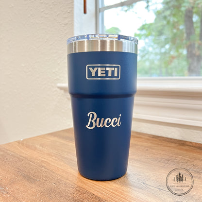 Blue YETI tumbler with 'Bucci' branding on a wooden surface.