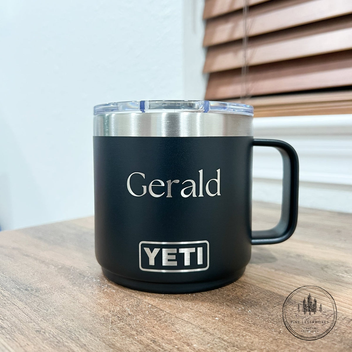 Black YETI mug with 'Gerald' on a wooden surface