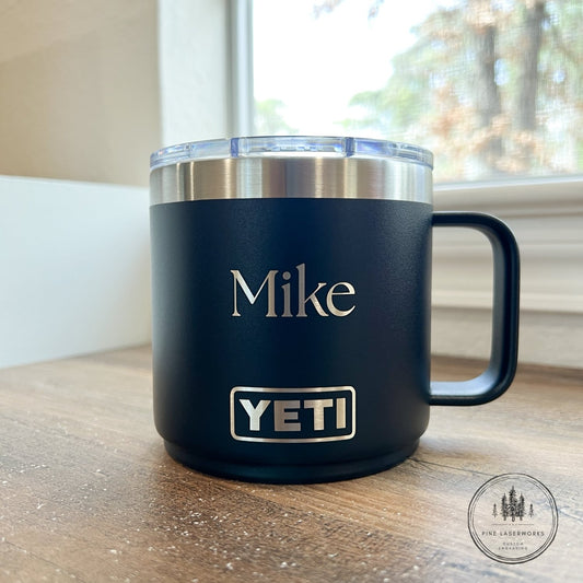 Black YETI mug with 'Mike' engraved on a wooden surface
