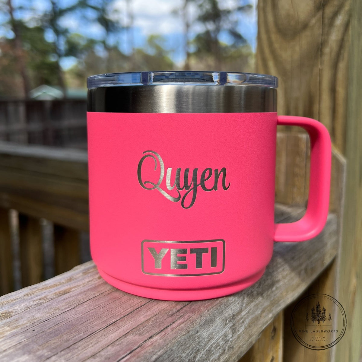 Pink YETI mug with 'Quyen' text on a wooden surface outdoors