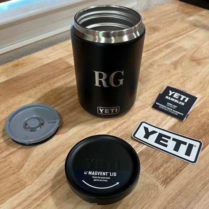 Black YETI mug with lid and accessories on a wooden surface