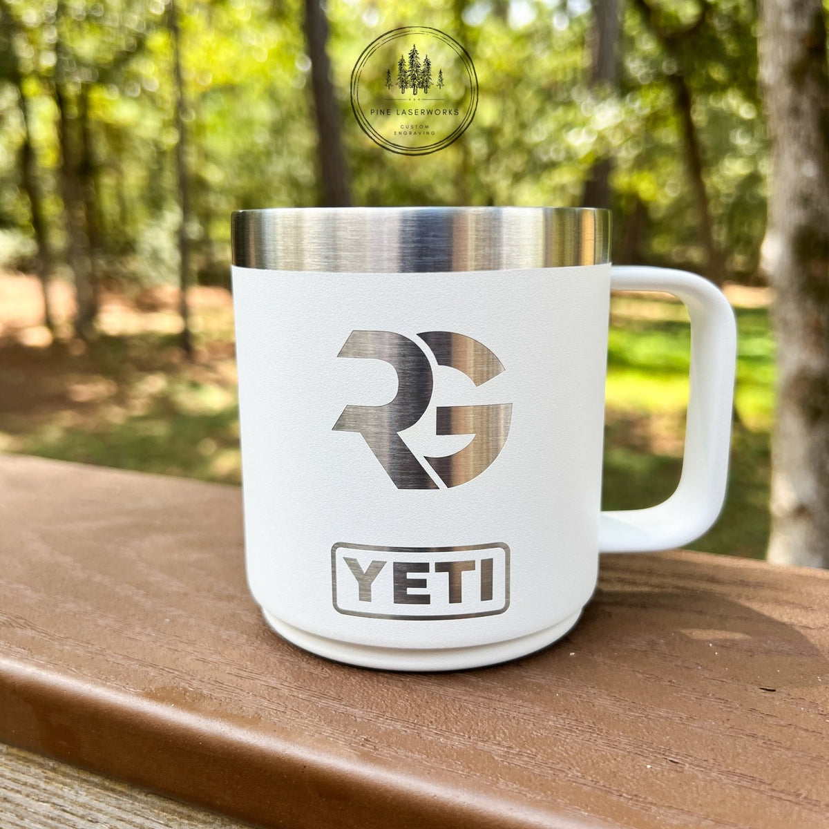 White YETI mug with logo on a wooden surface with a forest background