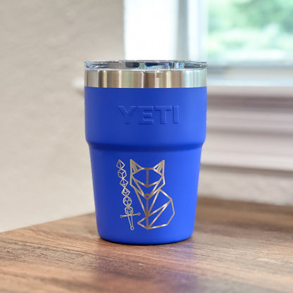 Ultramarine Violet Yeti 16oz Rambler Stackable Tumbler with a laser engraved logo on a wooden surface. 