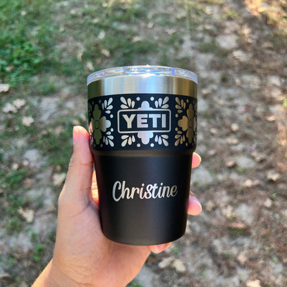 Personalized Talavera Flower Yeti 16oz Stackable Cup - Pine LaserworksHand holding a YETI branded tumbler with 'Christine' engraved on it against a natural background.