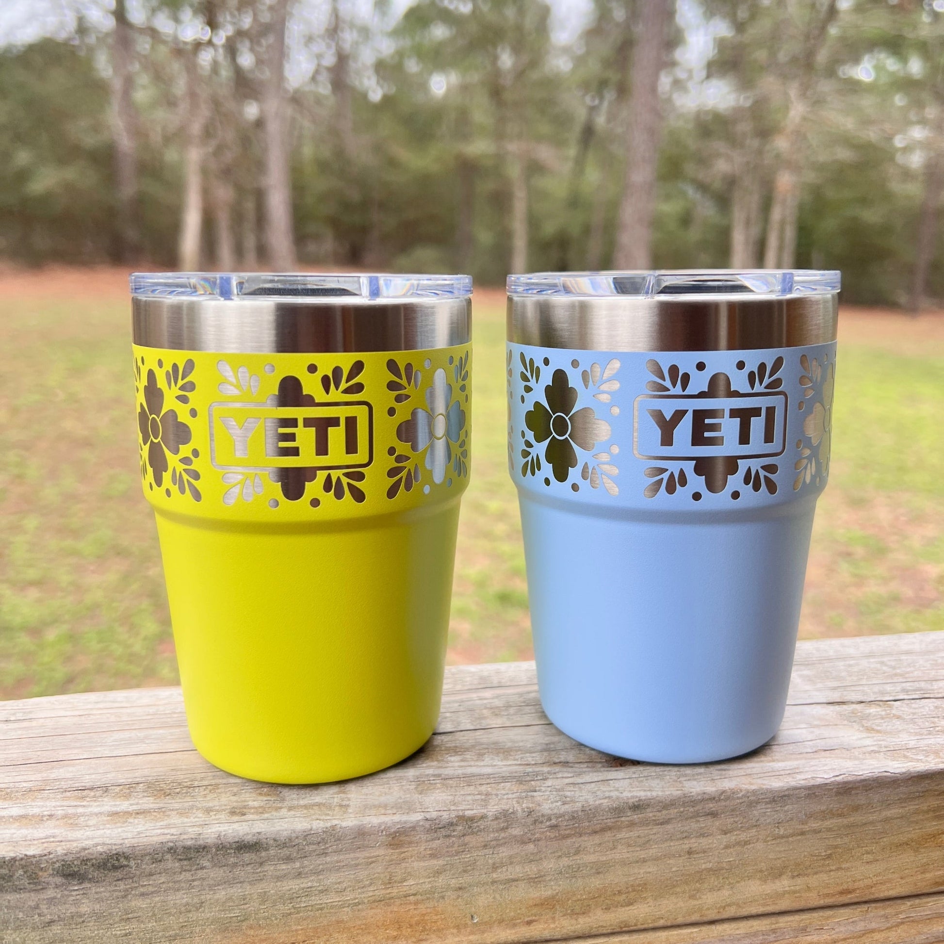 Talavera Flower Yeti 16oz Stackable Cup - Pine LaserworksFirefly Yellow and Big Sky Blue Yeti Tumblers on a wooden surface and outdoor background
